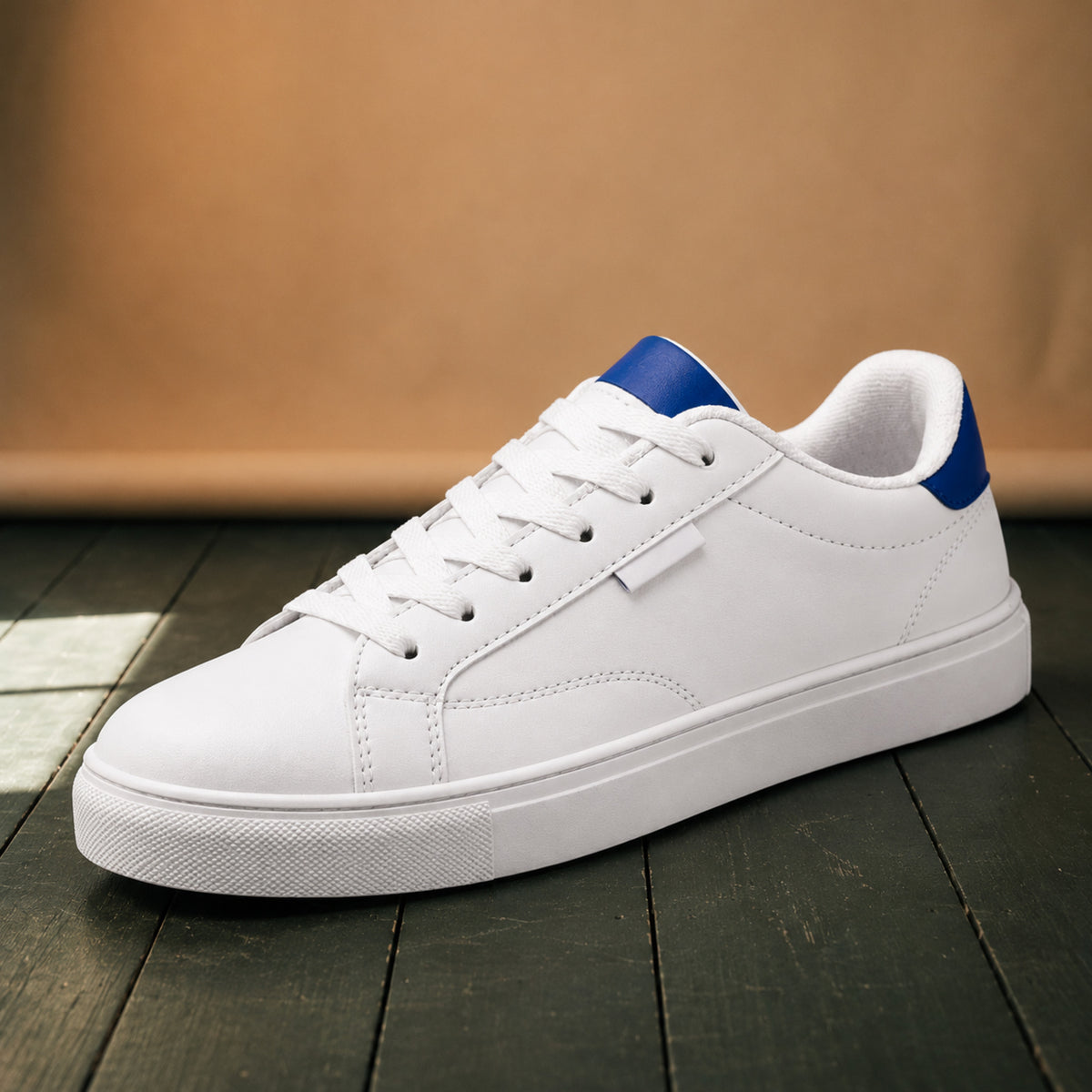 Gros plan sur le cuir blanc, la semelle en caoutchouc et le détail coloré au talon des baskets rétro années 80 Image
