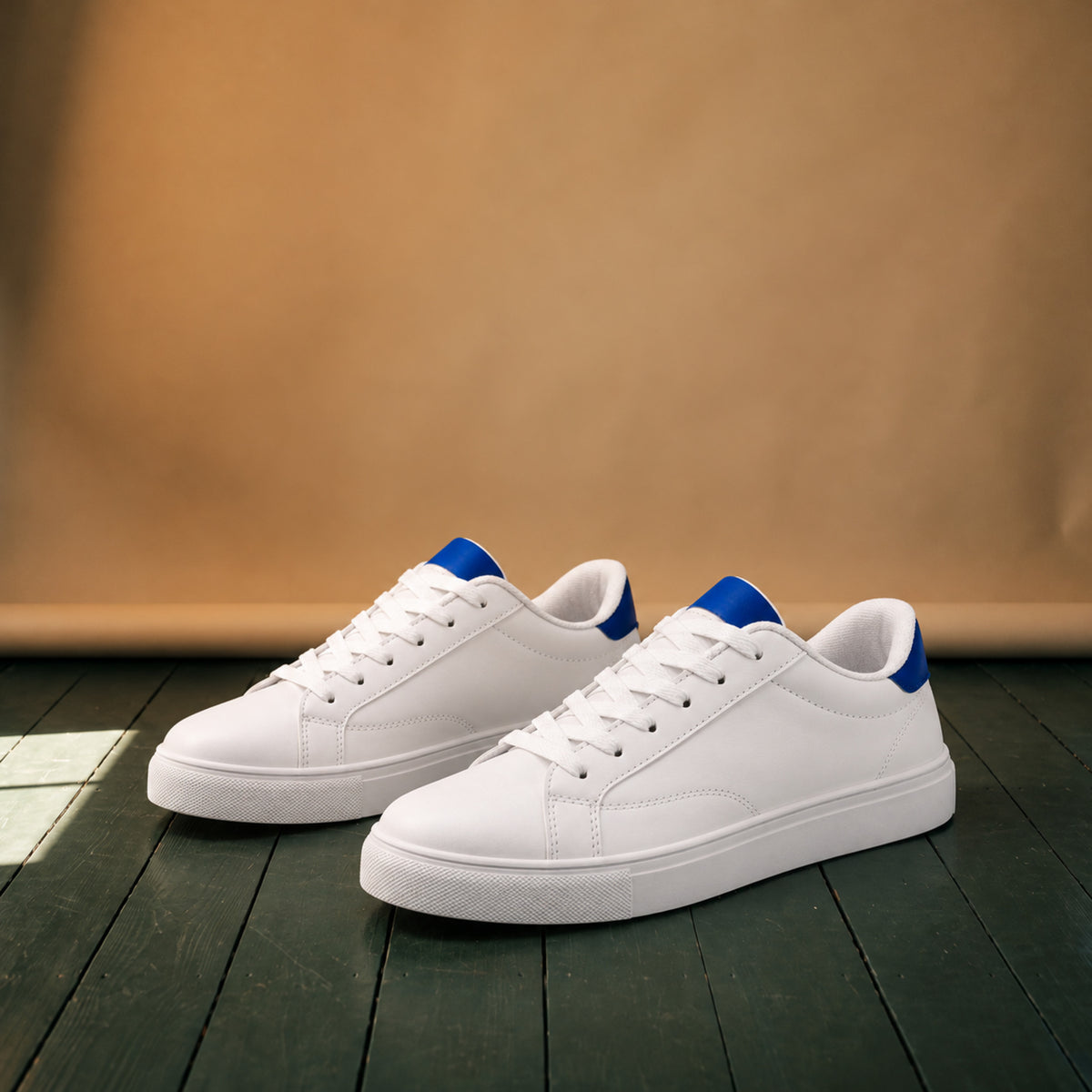 Paire de baskets blanches en cuir style rétro années 80 posée sur fond neutre, talon bleu visible Image