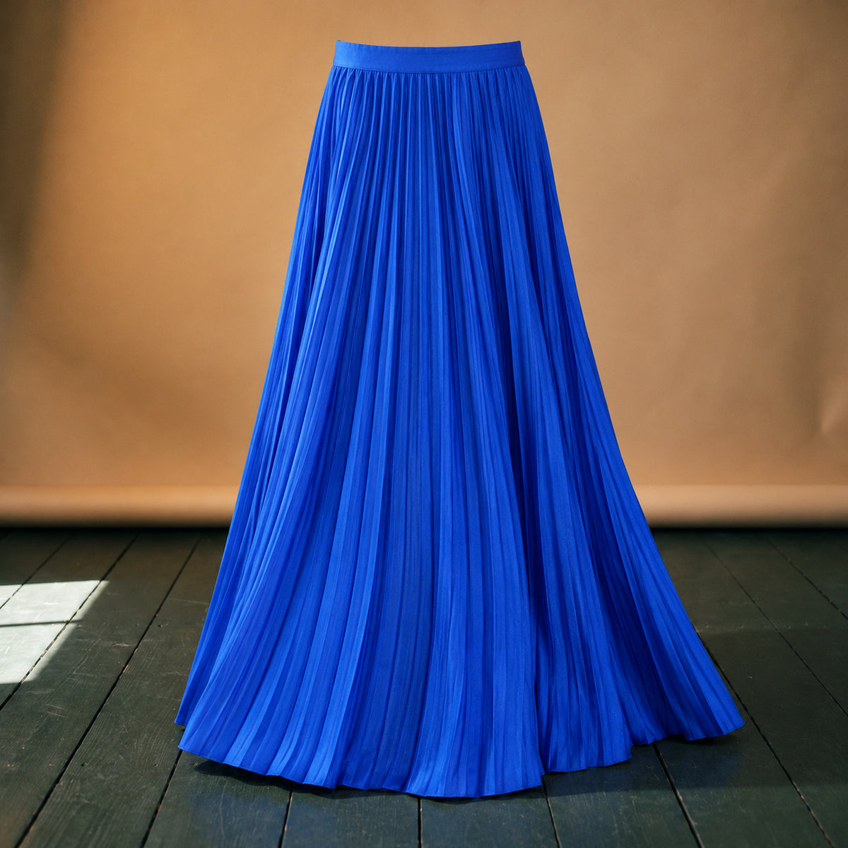 Gros plan sur les plis, le bleu roi uni et la taille élastique de la jupe longue plissée bleue style années 80 Image