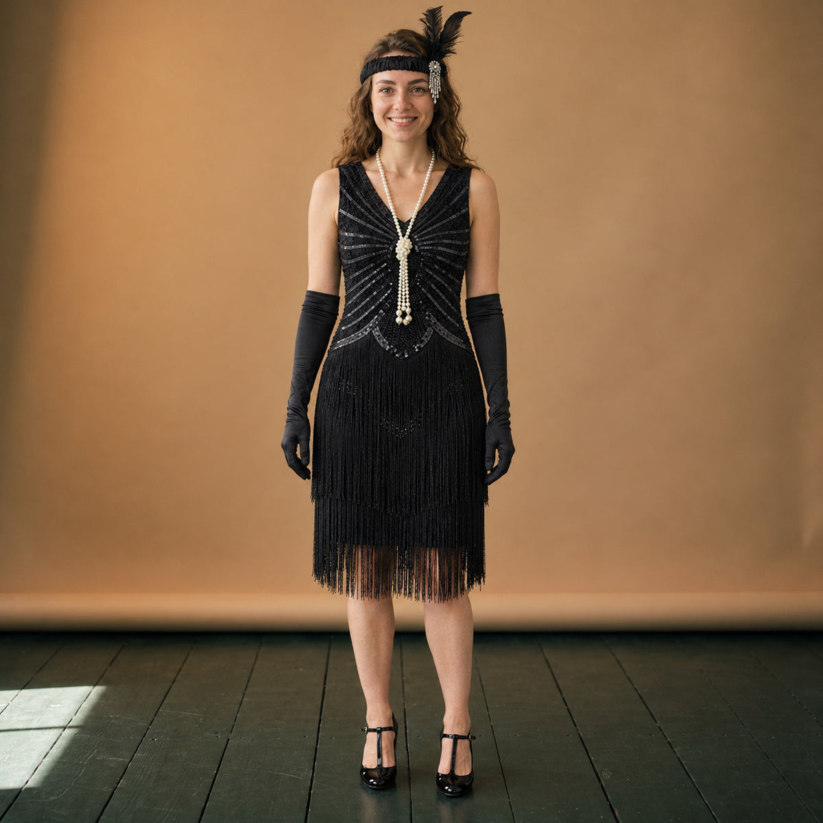 Robe années 20 charleston noire à franges et paillettes portée en studio, vue en pied Image