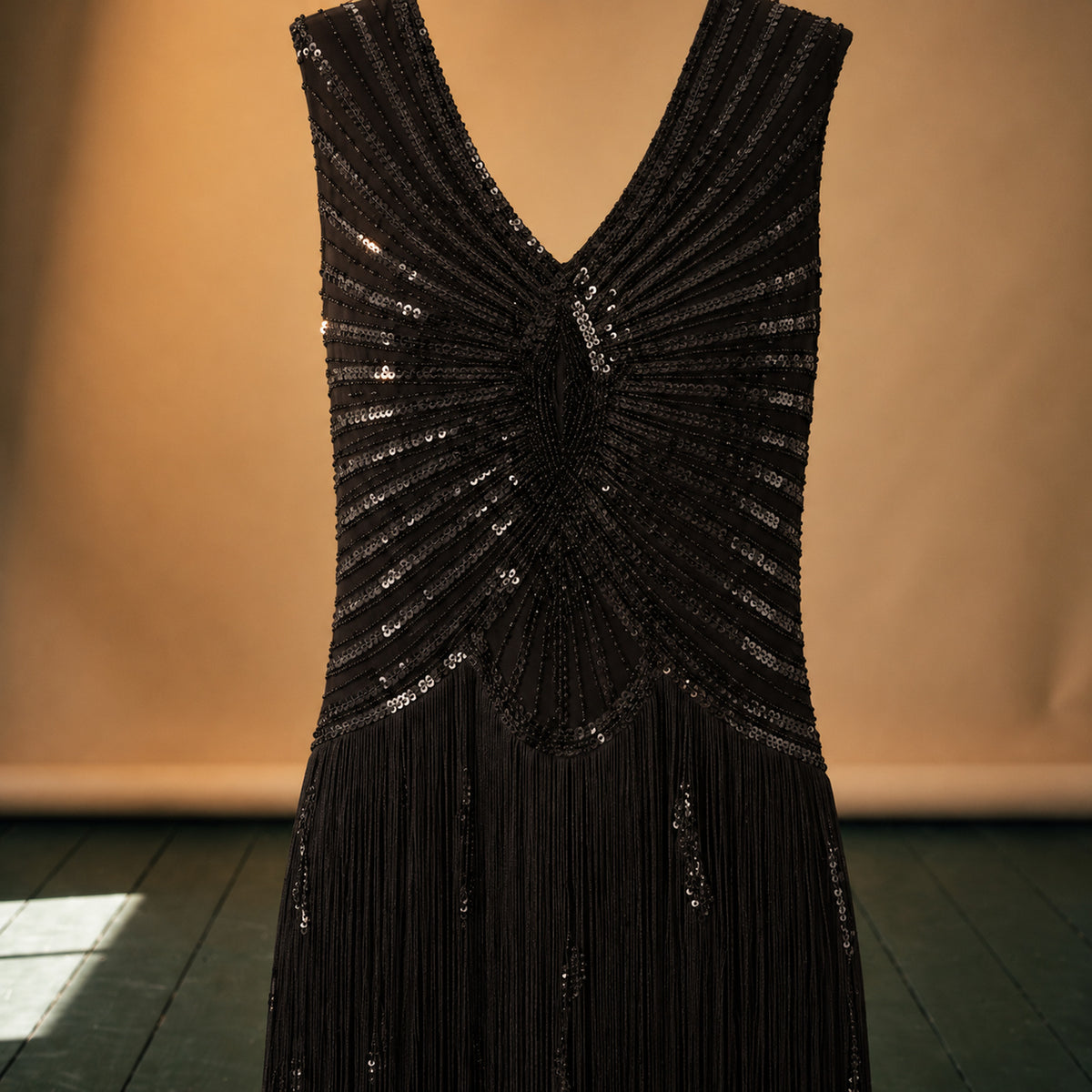 Gros plan sur les paillettes géométriques et les franges de la robe charleston Image