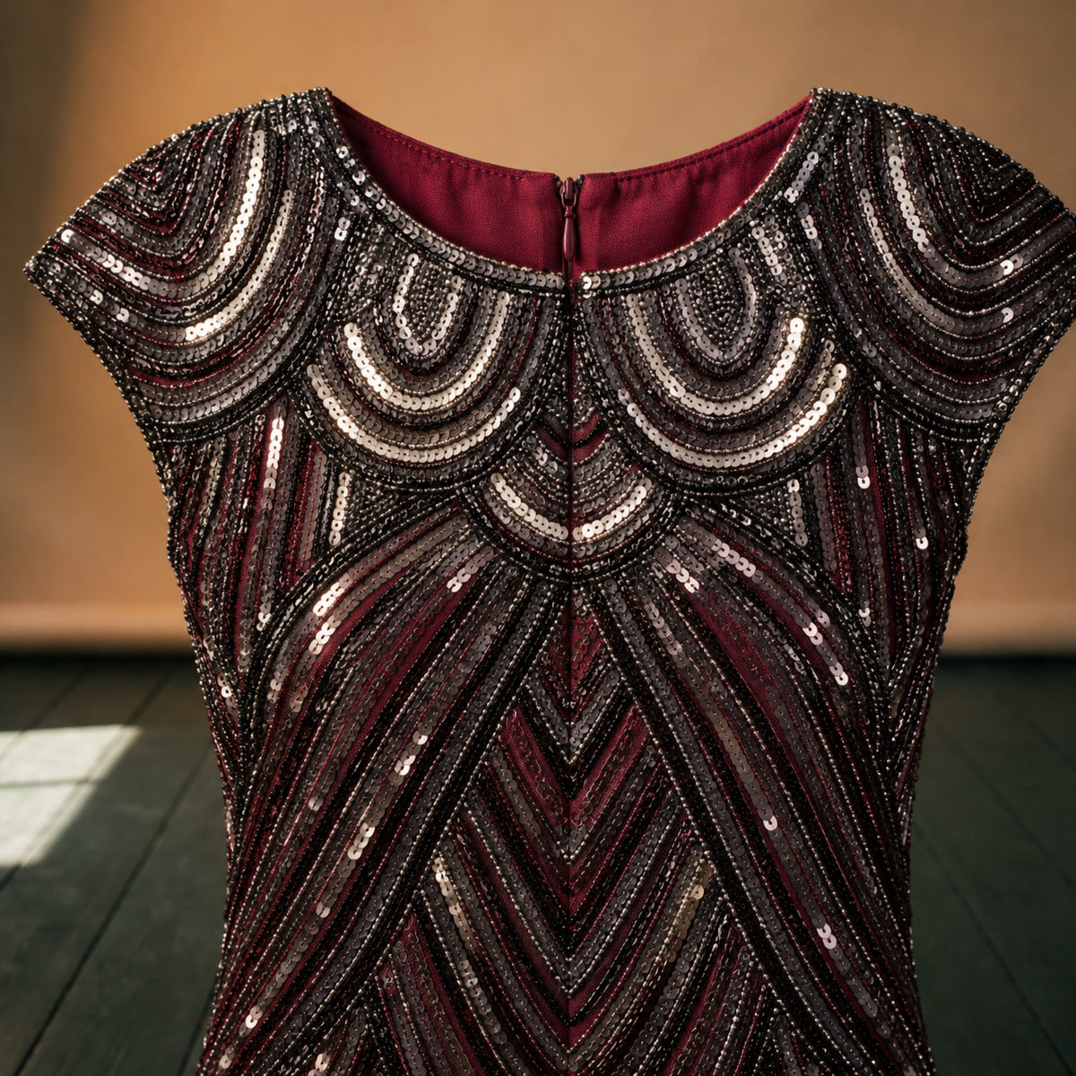 Gros plan sur les paillettes noires et argentées et les franges de la robe charleston rouge bordeaux Image