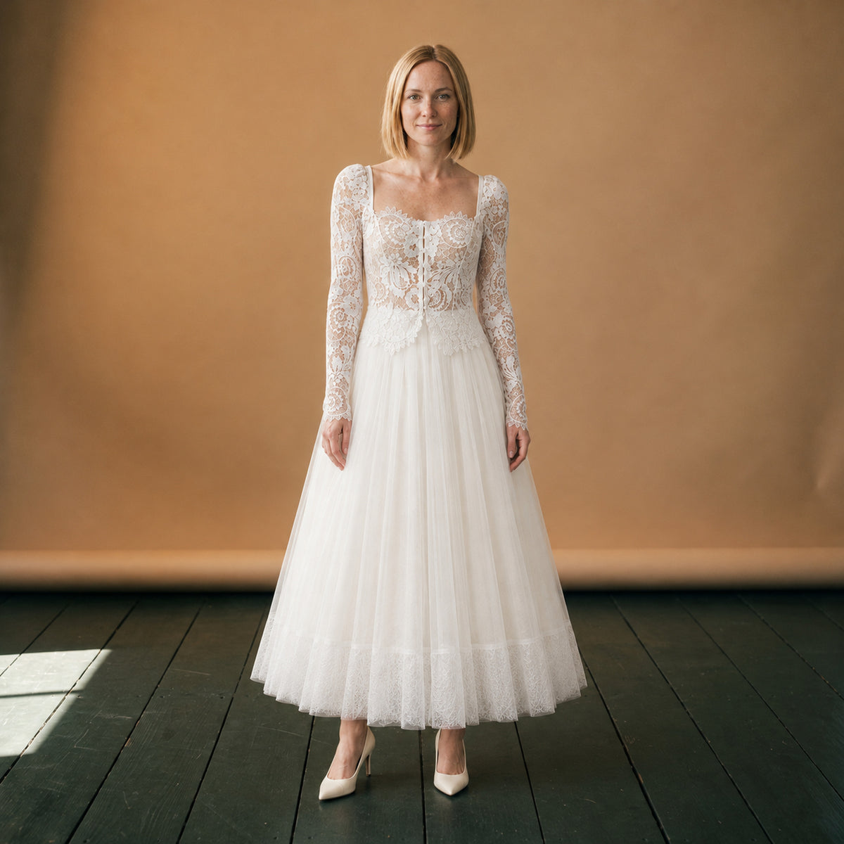 Robe de mariée vintage deux pièces en dentelle portée en studio, manches longues et jupe en tulle Image
