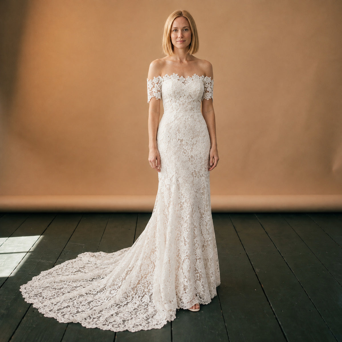 Robe de mariée bohème vintage en dentelle portée en studio, épaules dégagées et traîne, vue de face Image