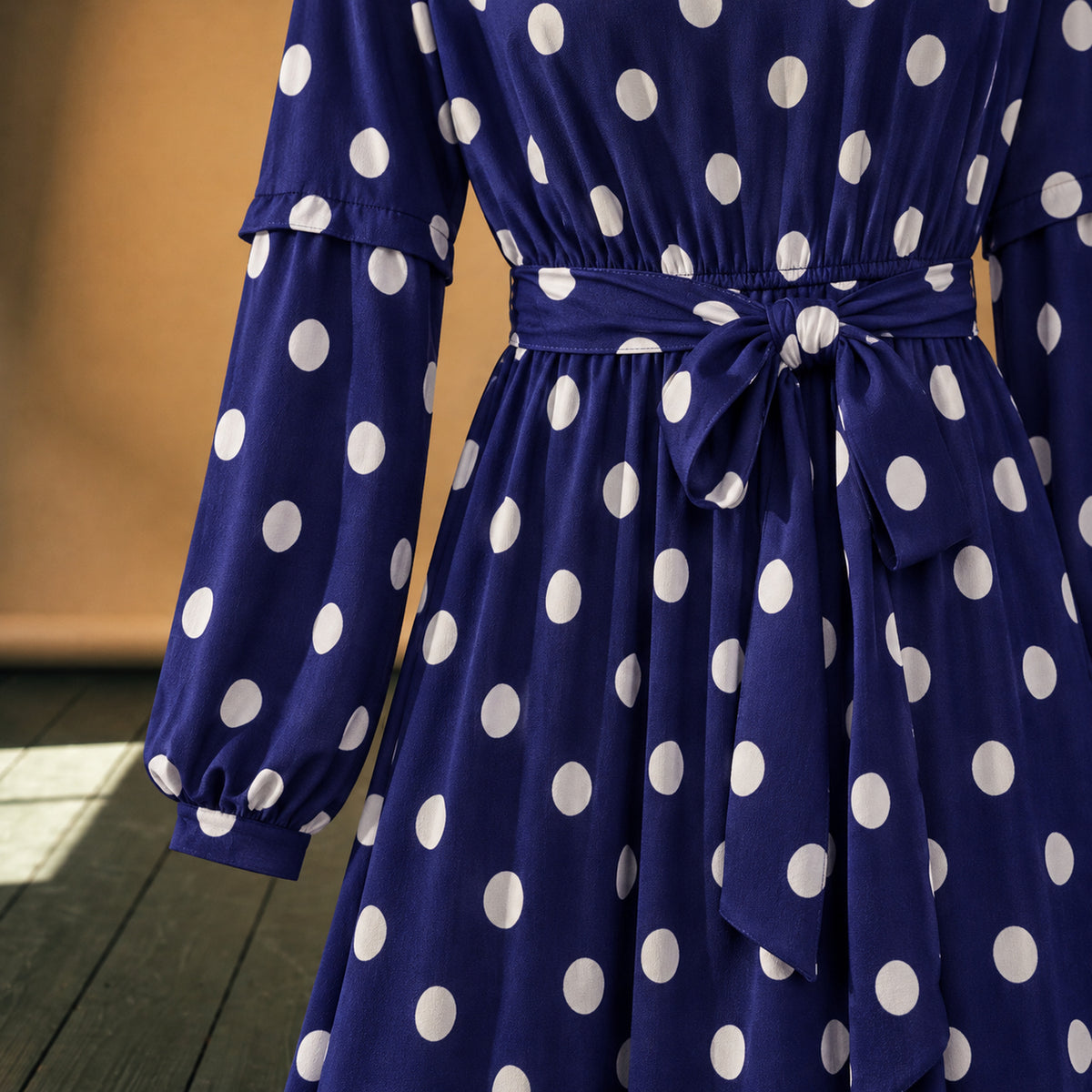 Gros plan sur les pois blancs, le polyester léger et la ceinture nouée de la robe maxi années 80 à pois bleus Image