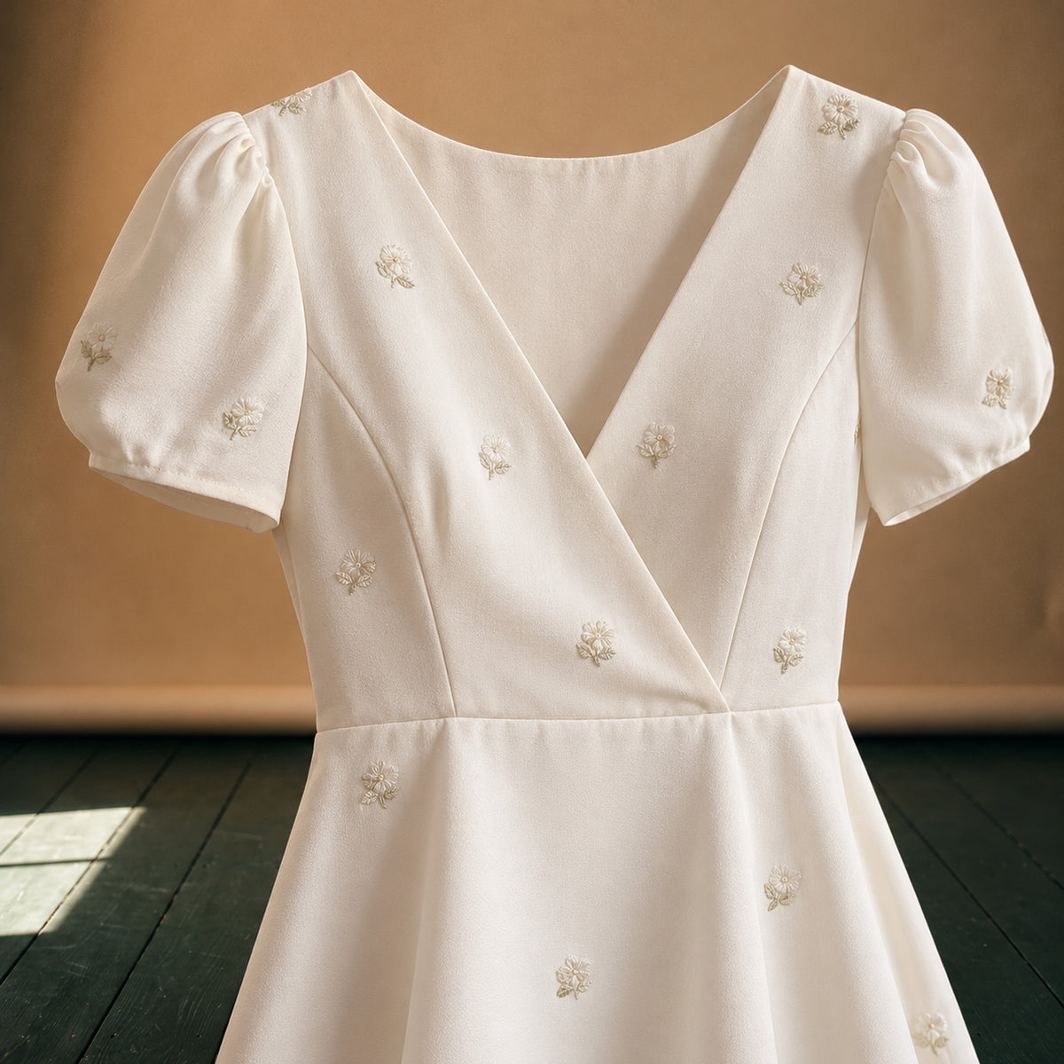Gros plan sur les petites fleurs brodées et le tissu lisse de la robe style charleston pour mariage Image